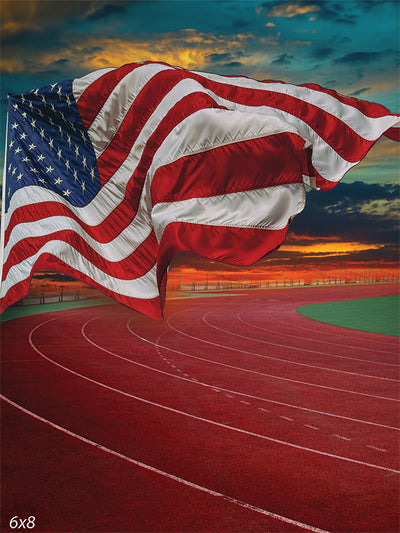 American Flag Over Track Photography Backdrop - A flowing American flag over a running track at sunset, used as a photography backdrop for patriotic and sports-themed photoshoots.