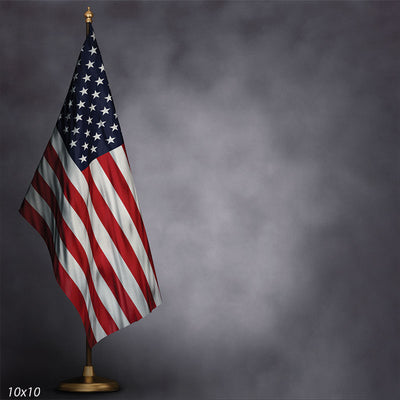 Classic U.S. flag on a gold stand set against a soft gray studio backdrop for patriotic portraits.