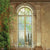 A stunning photography backdrop featuring an antique arched window set within a weathered stone wall, overlooking a misty countryside.