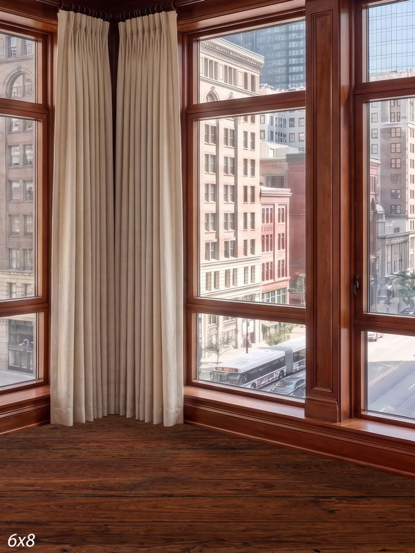 Traditional cherry-wood window corner with cream drapes overlooking a classic masonry downtown street, a city view photography backdrop.