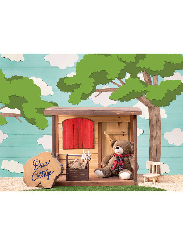 Bear Cottage Cake Smash Delight - Charming bear cottage backdrop with a wooden cottage, red window and door, teddy bear, trees, and clouds, perfect for cake smash and children's photoshoots.