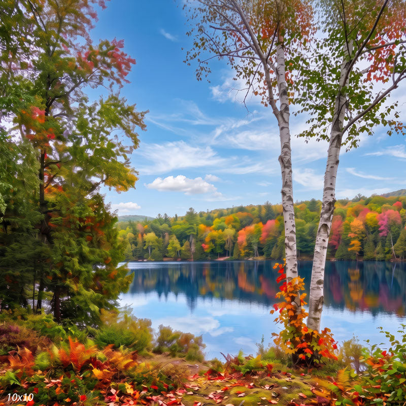 Autumn lake photography backdrop shown wider, with more sky, the mirrored tree line, and a leafy foreground along the shore.