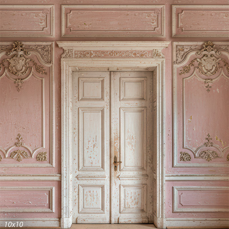 This studio background shows symmetrical ivory double doors surrounded by pink wall panels, layered moldings, and aged paint texture for portrait photography.