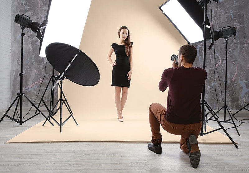 A model poses against a buff seamless paper backdrop, perfect for editorial and lifestyle photography.