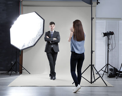 Studio headshot session featuring a light gray seamless photography backdrop paper for professional portraits.