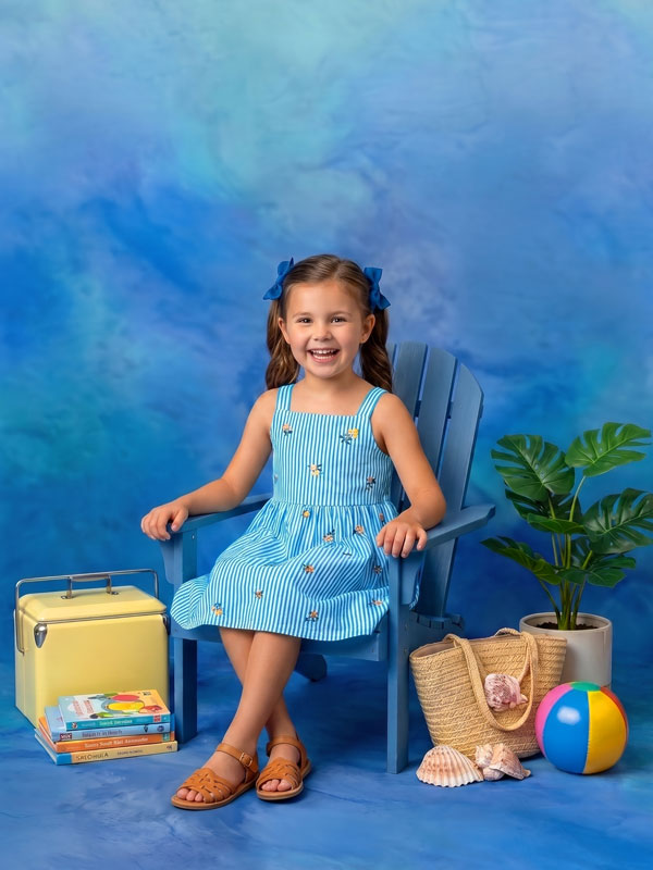 Cerulean Veil sky blue texture photography backdrop shown behind a young girl in a summer beach-themed setup CP-8979