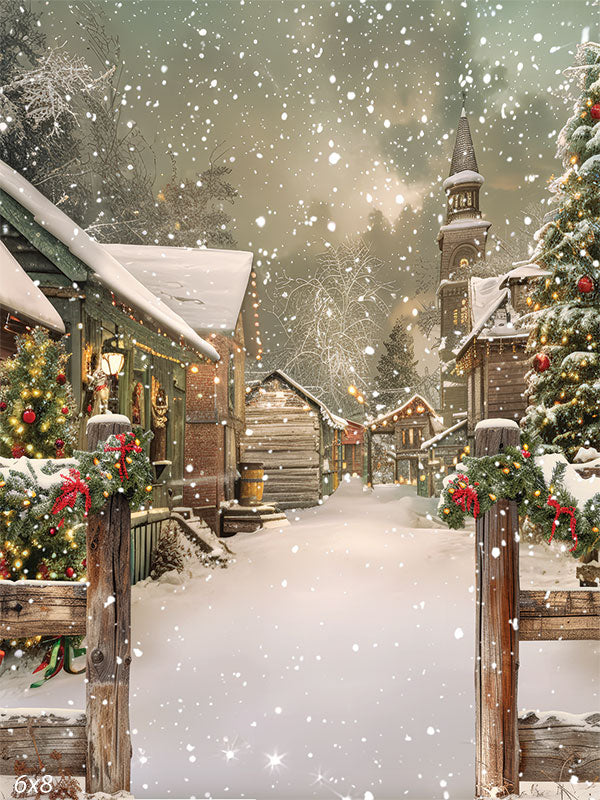 Charming Snow-Covered Holiday Village Backdrop - Charming snow-covered holiday village street with quaint wooden cottages adorned with garlands, wreaths, and twinkling lights, framed by rustic wooden posts and featuring a tall church steeple in the background under a snowy sky.