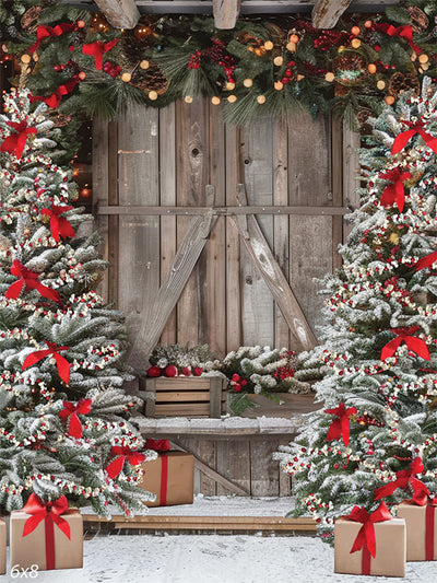 Christmas Winter Barn Photography Backdrop - Rustic barn decorated for Christmas with snow-covered trees, red bows, festive ornaments, and a garland of greenery and pinecones.