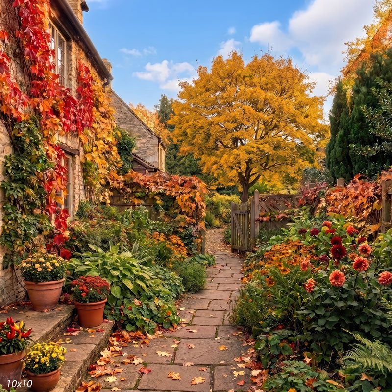 Autumn cottage garden photography backdrop shown wider, with the flagstone path, blue sky, golden maple, and layered borders of orange and gold foliage.