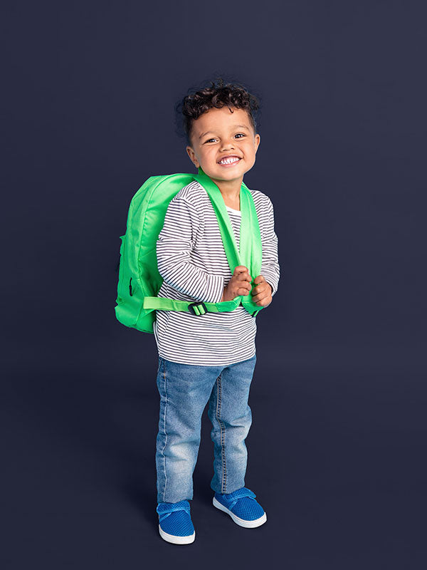 A young child poses against a cobalt blue seamless backdrop paper, highlighting its versatility for studio photography.