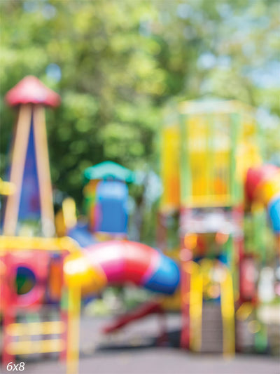 Colorful Playground Photography Backdrop with Blurred Bokeh Effect - Blurred colorful playground with slides, climbing structures, and swings, creating a vibrant and cheerful photography backdrop.