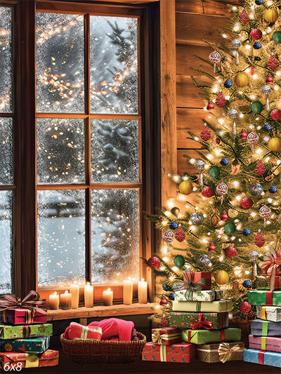 Cozy Christmas Cabin Backdrop - A cozy Christmas cabin scene featuring a beautifully decorated Christmas tree with colorful ornaments, surrounded by wrapped gifts. A large wooden-framed window shows a snowy night outside, with candles glowing on the window sill.