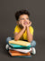 A child posing with books against a dark gray seamless photography backdrop for commercial use.