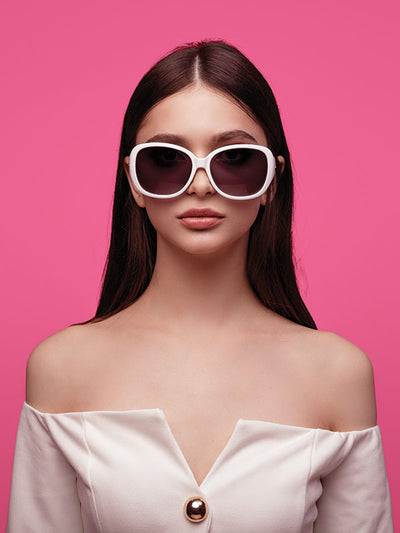 A close-up portrait of a woman in front of a deep pink seamless backdrop, ideal for studio photography.