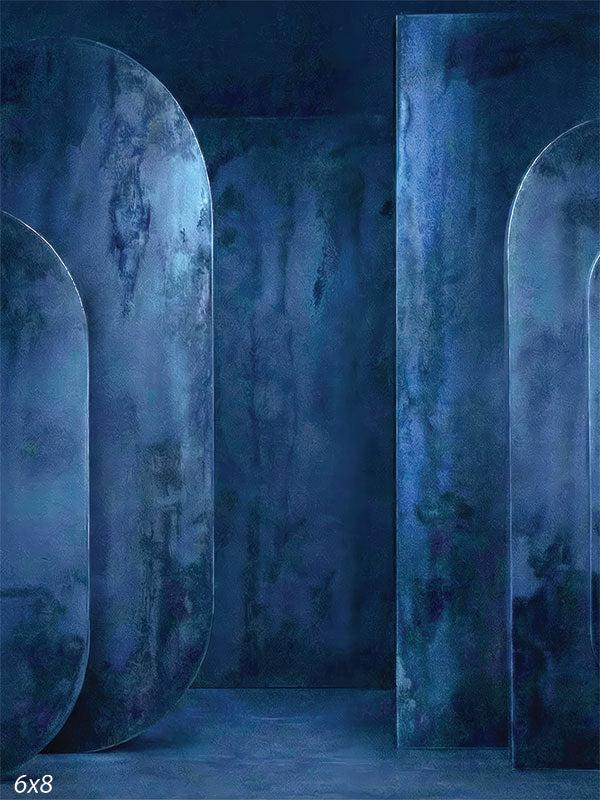 Deep blue photography backdrop featuring textured oval panel forms with layered plaster-style surfaces arranged in an architectural studio setting.