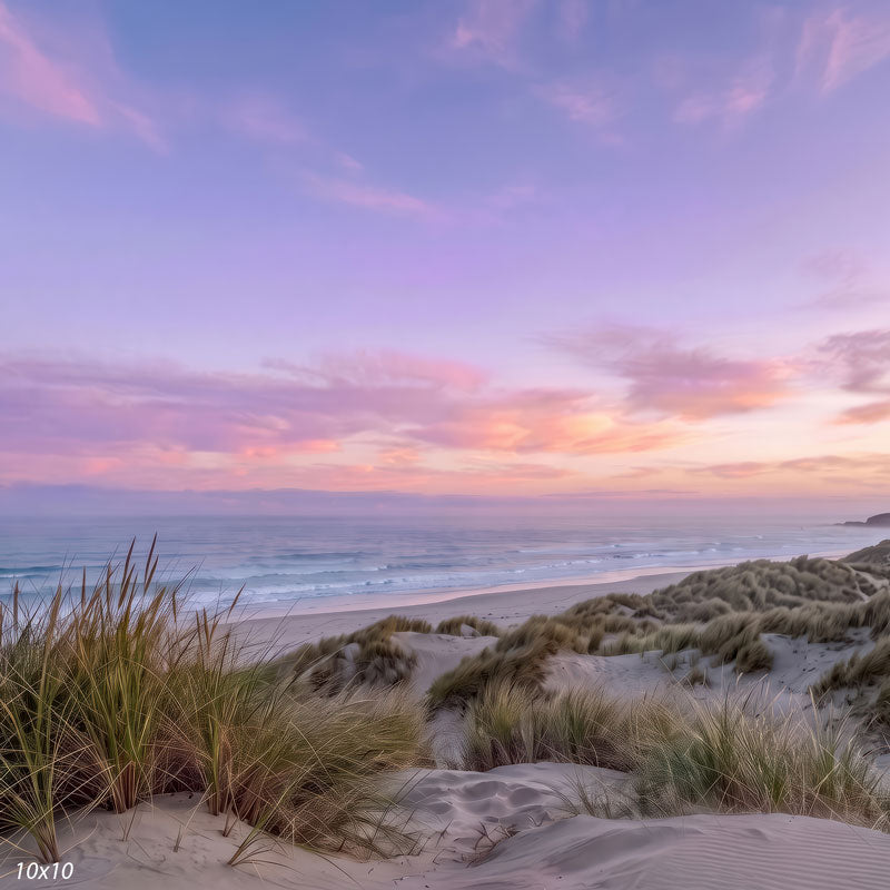 Pastel beach photography backdrop shown wider, with more sky, open ocean, and sea-grass dunes beneath the pastel sunset.