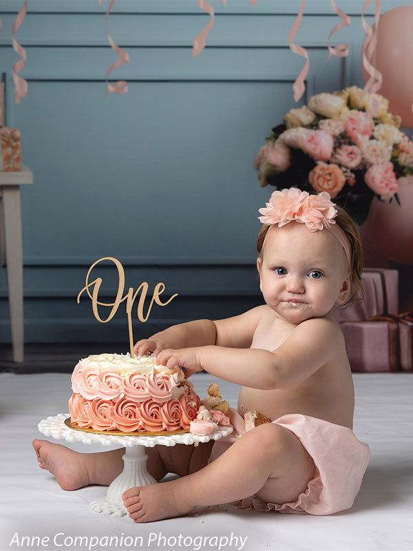 Elegant birthday photography backdrop featuring soft peach, blue, and white balloons, floral arrangements, wrapped presents, and a chic pastel background for a dreamy celebration setting.