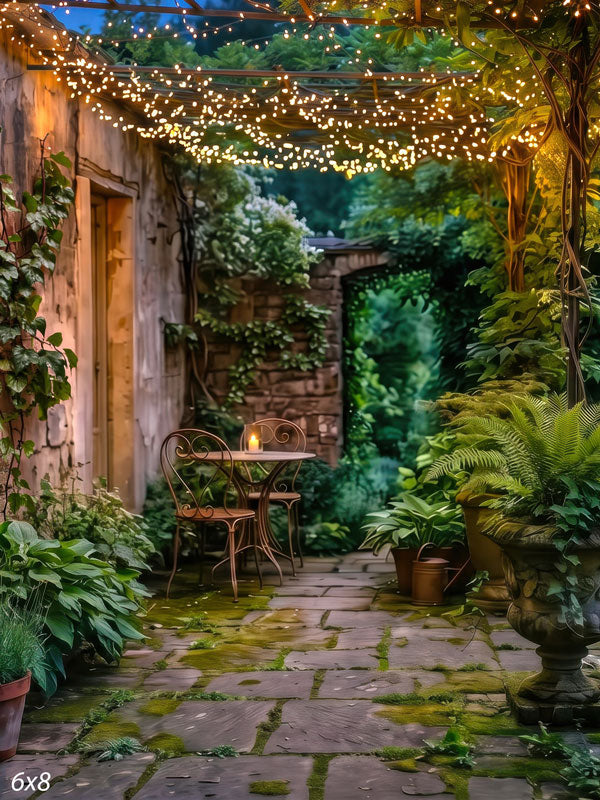 Garden courtyard at dusk beneath a pergola strung with warm fairy lights, with a bistro table and ferns on mossy flagstone, a scenic photography backdrop.