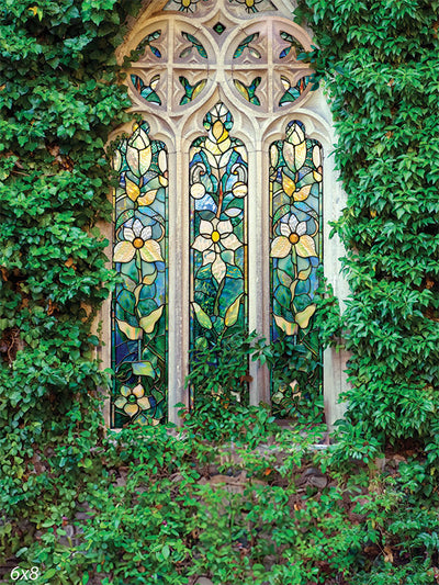 A detailed stained glass window with floral patterns surrounded by lush green ivy, ideal for professional spring and Easter photography.