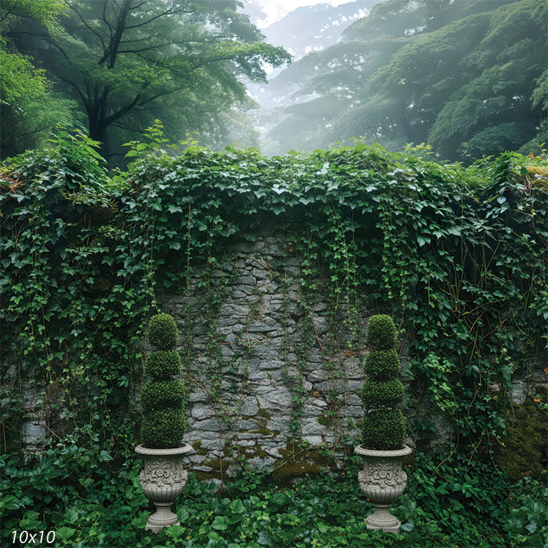Printed studio background featuring a centered stone wall with trailing ivy vines, dense foliage at the base, and matching topiary urns on both sides. A misty forest canopy appears above the wall.