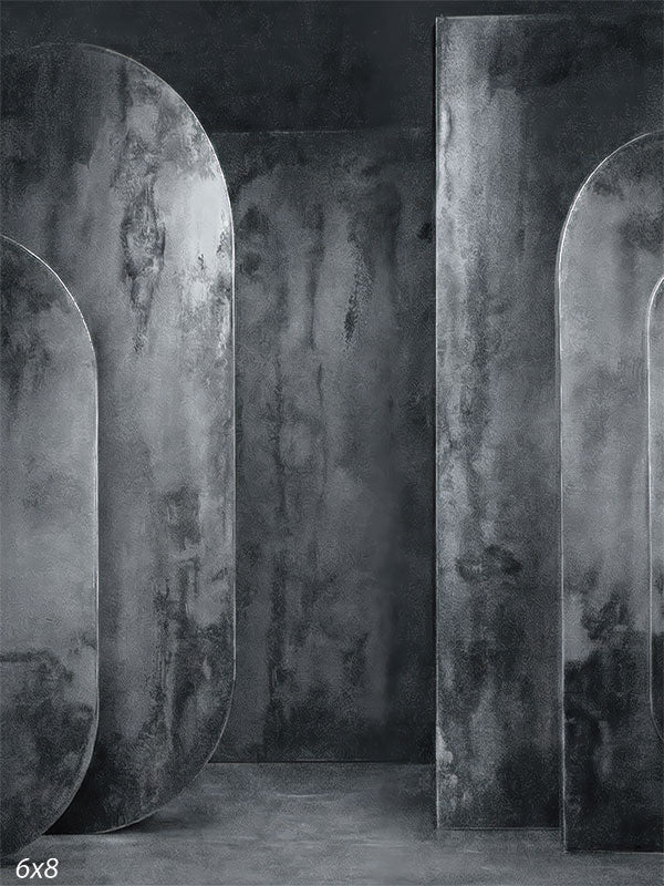 Gray photography backdrop featuring textured oval panel forms with concrete-style surfaces arranged in an architectural studio setting.