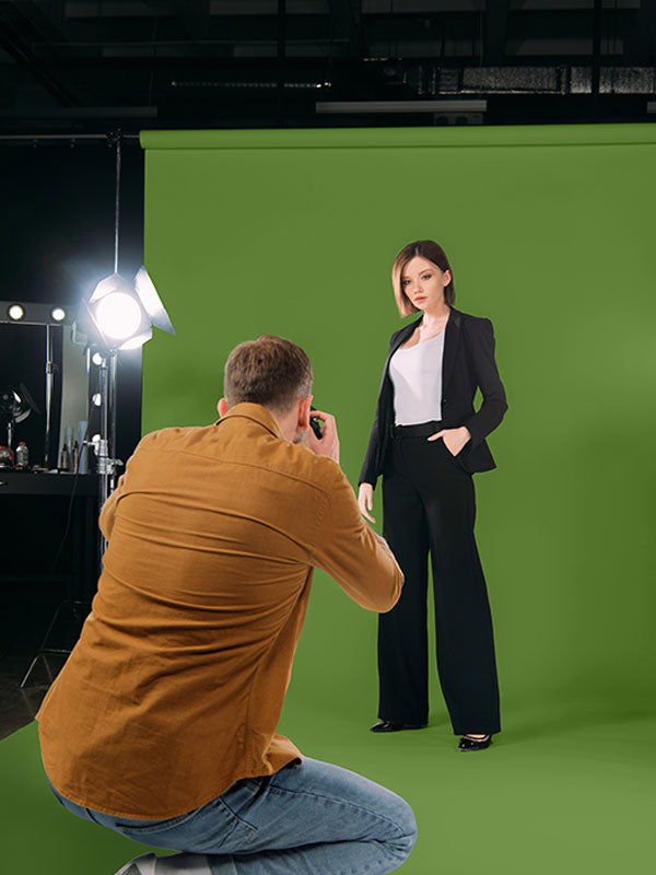 A green screen backdrop used in a professional studio setting for portrait photography and video shooting.

