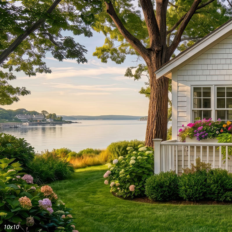 Wider view of the seaside cottage garden, showing more of the hydrangea beds and calm bay, a scenic coastal photography backdrop.