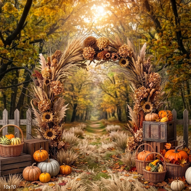 Autumn harvest photography backdrop shown wider, with the full floral arch, more of the blurred autumn forest path, and pumpkins and crates along the ground.
