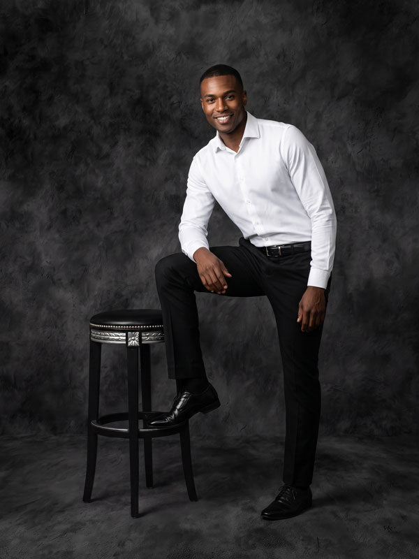 Ironstone charcoal texture photography backdrop shown behind a man in a white shirt beside a stool CP-8987