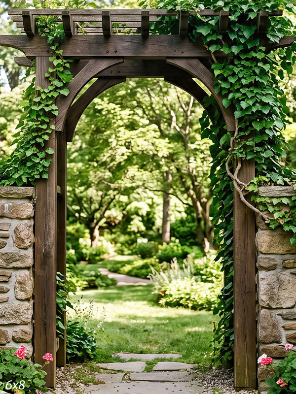 Dark timber garden arbor on dry-stacked stone pillars covered in heavy ivy, opening onto a lawn and stepping-stone path, a photography backdrop.