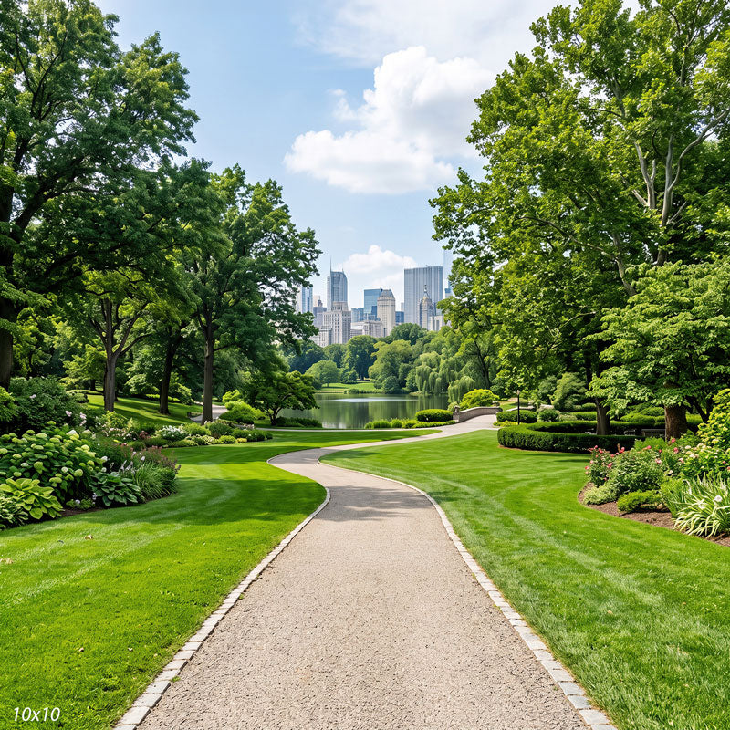 Wider view of the city park showing more path and flower borders and a broader span of the skyline above the trees, a scenic photography backdrop.