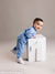 Smiling baby boy in milestone session with clean gray background—great for family and birthday photographers.