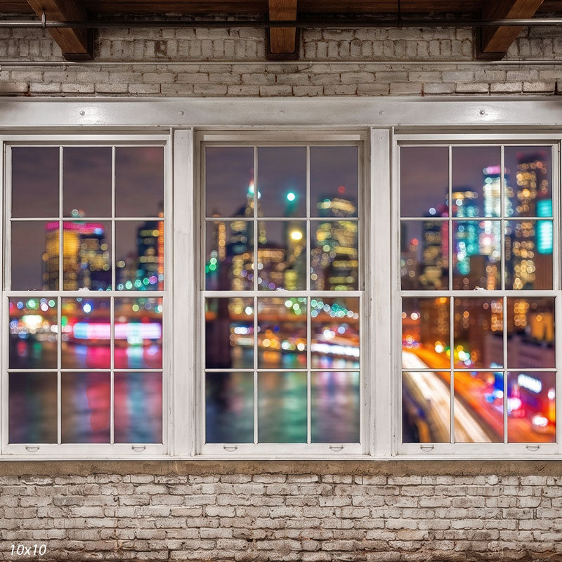 Wider view of the whitewashed loft showing more of the white window frames, wood beams, and colorful bokeh city lights, an urban photography backdrop.