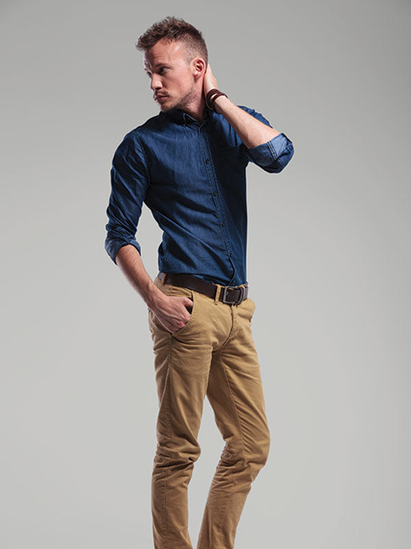 Male model posing in front of a light gray seamless photography backdrop paper in a professional studio setting.