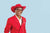 Male model wearing a red suit posing in front of a light blue seamless photography backdrop paper in a studio setting.