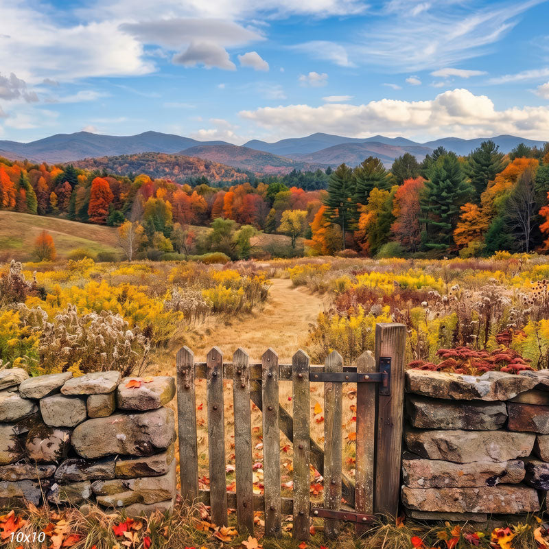 Autumn mountain meadow photography backdrop shown wider, with a blue mountain ridge, drifting clouds, and a golden meadow path behind a rustic stone-walled gate.