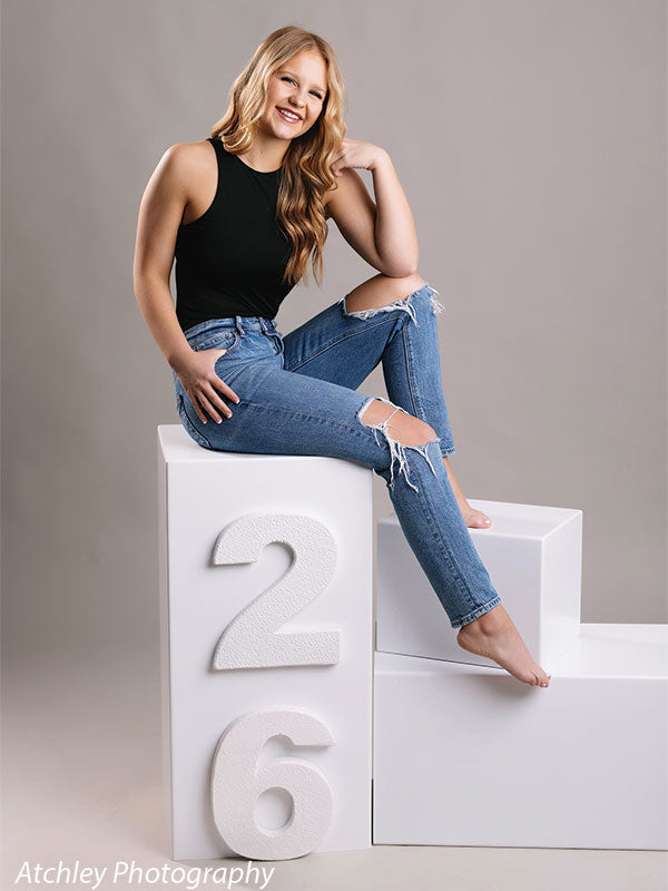 Modern senior portrait setup on number blocks with smooth light gray backdrop—ideal for high school photographers.