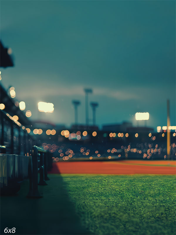 Baseball stadium backdrop featuring a green field, dugout view, and illuminated stadium lights for sports photography sessions.