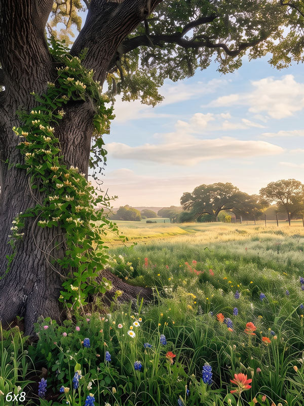 Large live oak wrapped in flowering honeysuckle vine beside a meadow of bluebonnets, red paintbrush and daisies with open pasture behind, a photography backdrop.