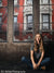 Seated studio portrait with urban red brick loft backdrop—designed for school and senior photography.