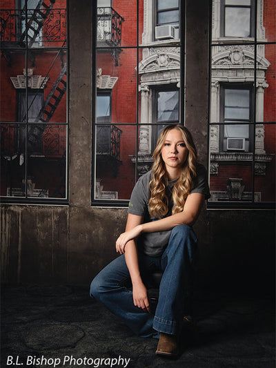 Gritty studio backdrop with loft windows and red brick—ideal for senior portraits or school photographer use.
