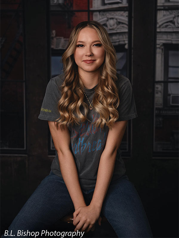 Urban senior portrait backdrop with red brick and loft-style windows—perfect for modern studio sessions.