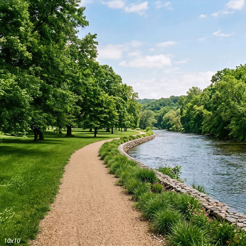 Wider view of the riverside park showing more of the tree-lined bank and a longer stretch of the river curving into the distance, a scenic photography backdrop.