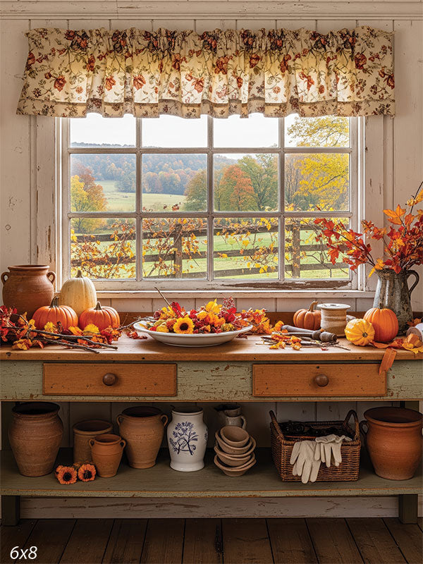 A cozy autumn backdrop featuring a farmhouse table with pumpkins, pottery, and fall leaves, set against a scenic countryside view.