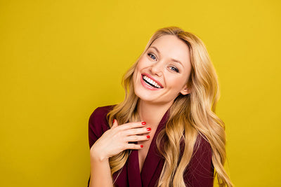 Female model posing against a lemon yellow seamless photography backdrop paper for portrait photography.