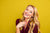 Female model posing against a lemon yellow seamless photography backdrop paper for portrait photography.