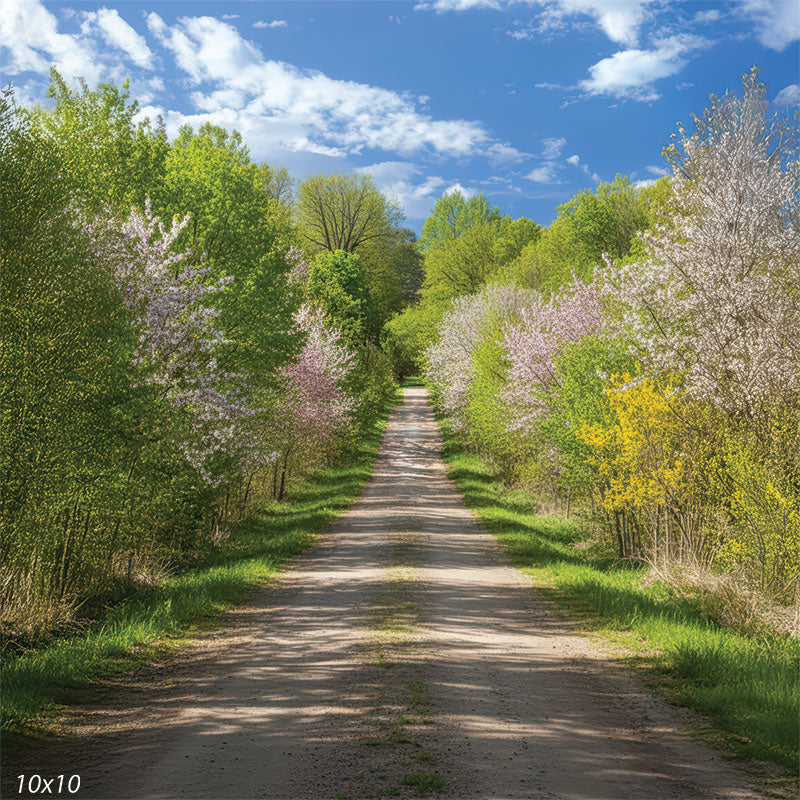 A photography backdrop featuring a country path flanked by flowering spring bushes and green trees.