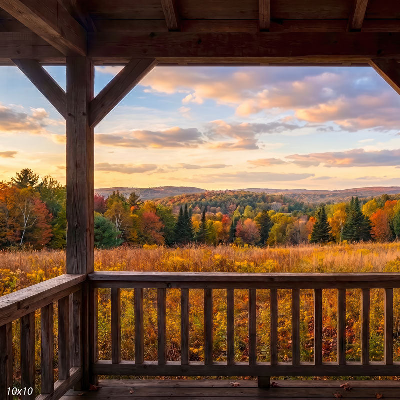 Autumn valley photography backdrop shown wider, with more of the porch, a golden field, and a peach-toned sunset sky over the foliage.