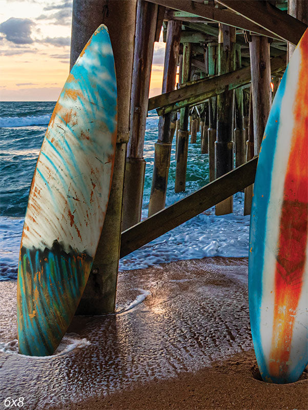 Sunset Surf Photography Backdrop - A serene beach photography backdrop featuring surfboards under a pier at sunset with ocean waves in the background.