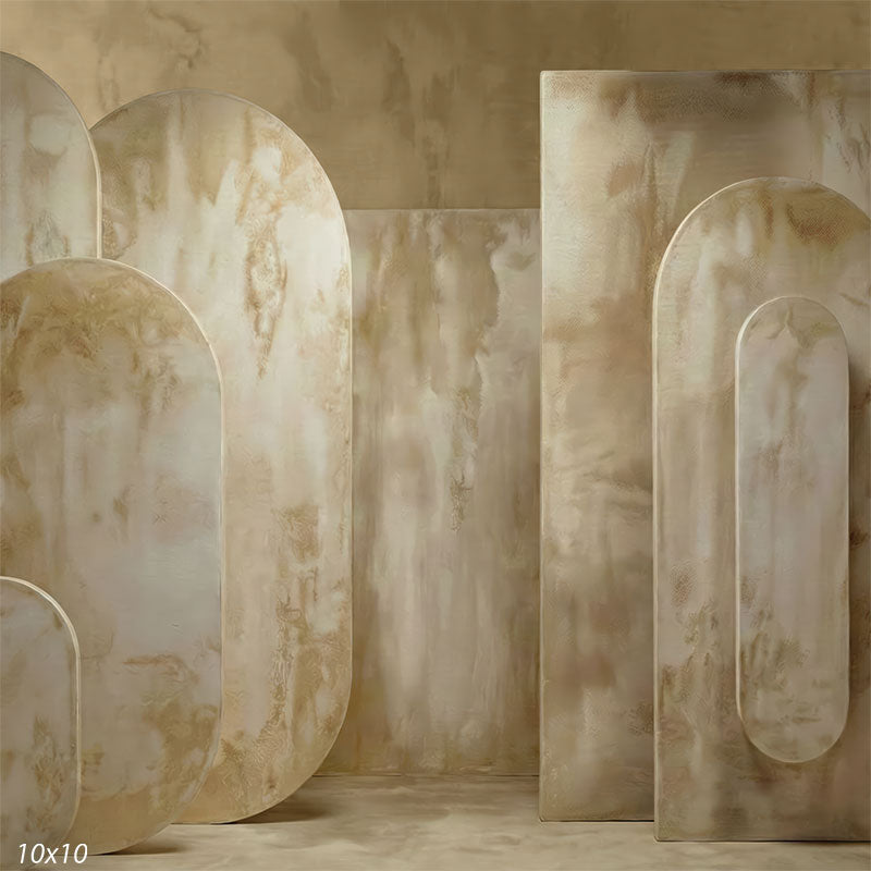 Studio background showing warm beige plaster surfaces with rounded arch panels and subtle mottled texture for portrait photography.